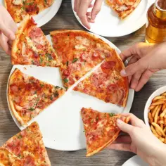 Ludzie jedzą pizzę i frytki, pijąc piwo.