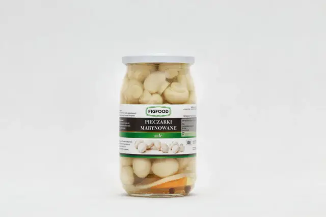 Słoik pieczarek marynowanych marki Figfood z widocznymi pieczarkami, marchewką i przyprawami.